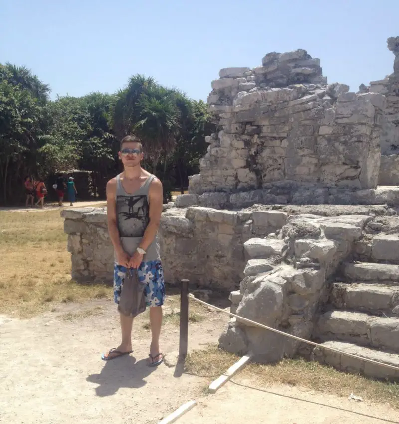 A photo of a man posing at Tulum ruins