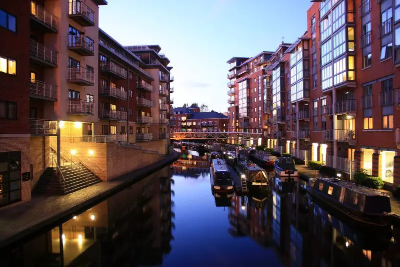 a view of the still waters of the worcester and birmingham canal in the gas street basin area of birmingham city centre, during sunset