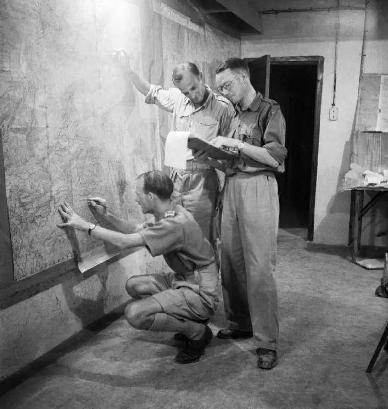 Staff_officers_plotting_troop_positions_during_the_invasion_of_Sicily_on_a_wall_map_in_the_underground_operations_room_at_Malta,_9_July_1943