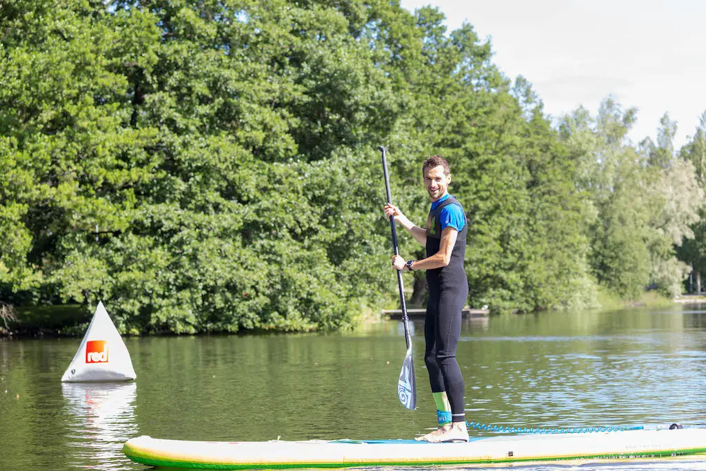 close up of a man smiling as he paddleboards on alderford lake