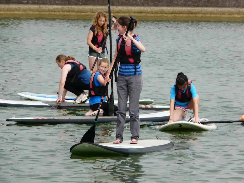 close up of five children paddleboarding at edgbaston reservoir in birmingham