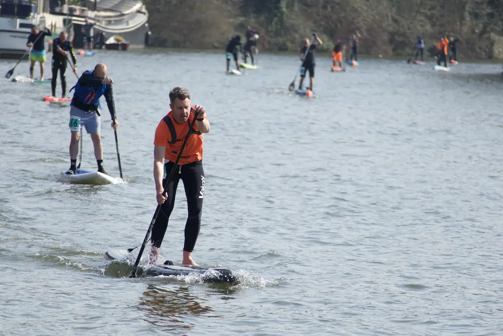 view of several people taking part in a paddleboard race on a lake in dudley, england