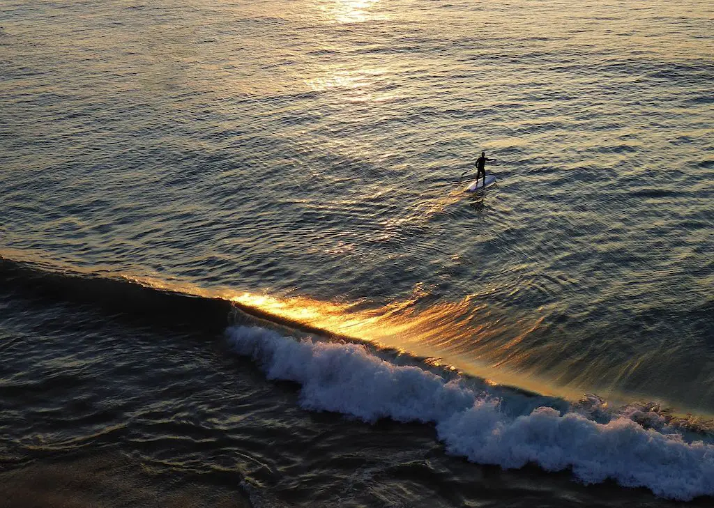 a man paddleboarding on the sea at cullercoats bay, england
