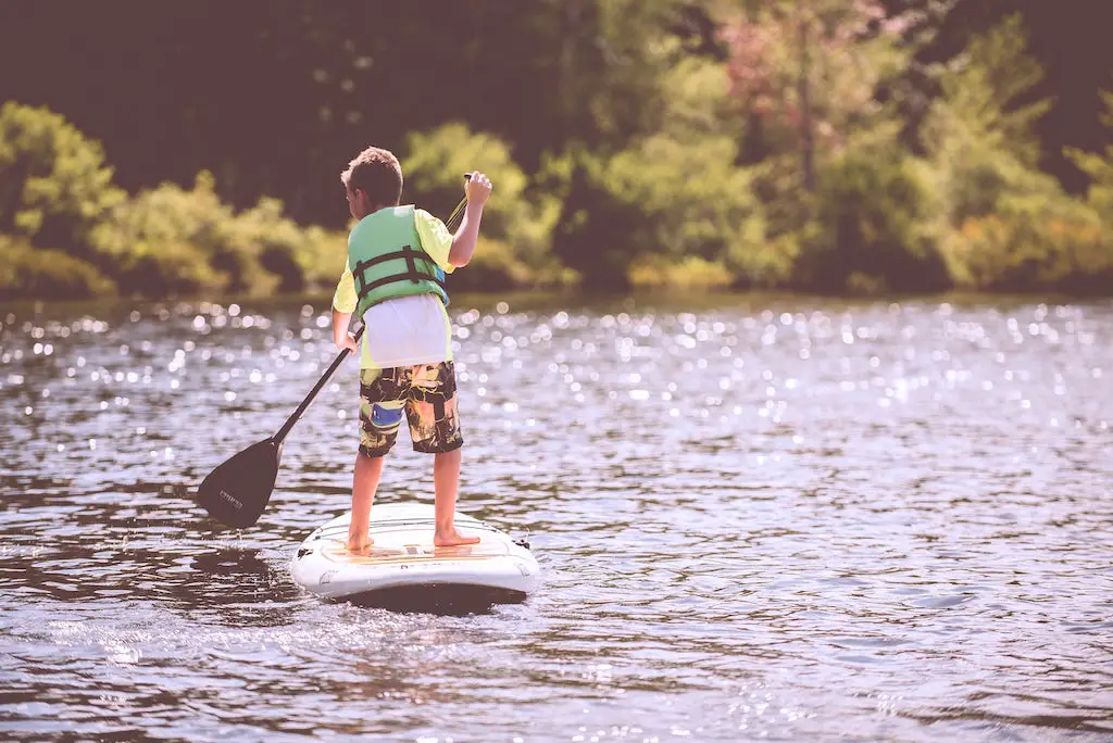 boy paddleboarding on the symonds yat river in wales