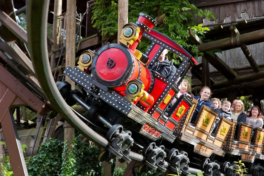 an old fashioned train rollercoaster with people sitting inside at alton towers theme park