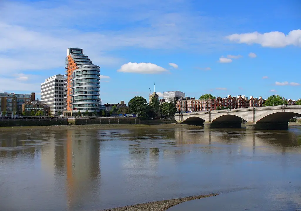 view of putney bridge with some tall buildings in the distance, in london