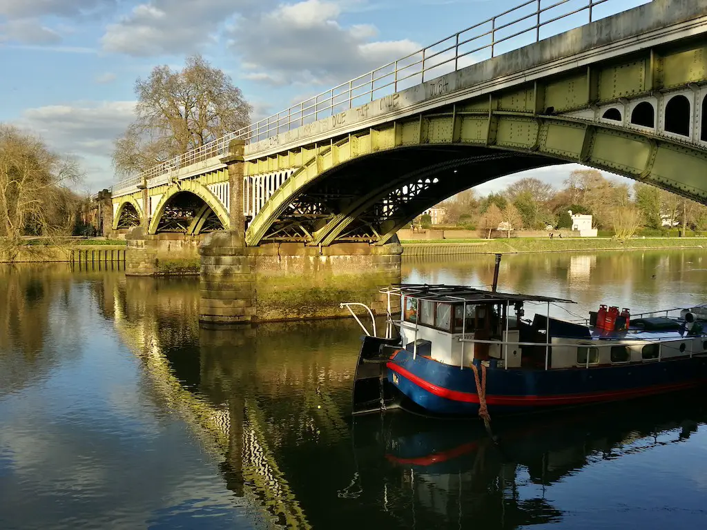 a view from one end of richmond bridge with a barge sailing underneath it, in london