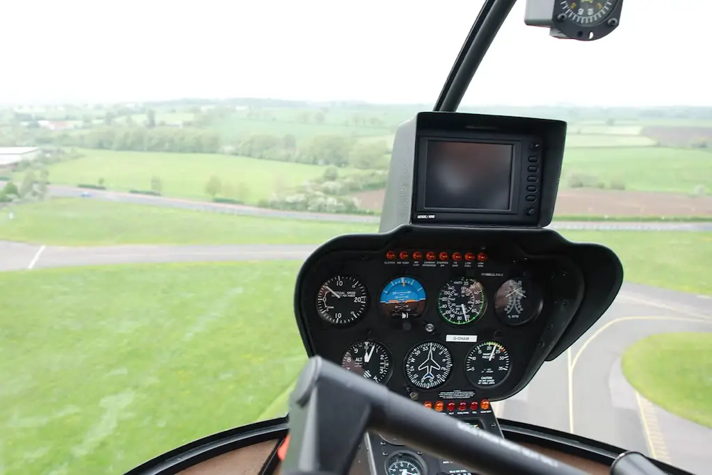 a view of the cockpit inside the helicopter and the cardiff scenery as the helicopter ascends from the helipad