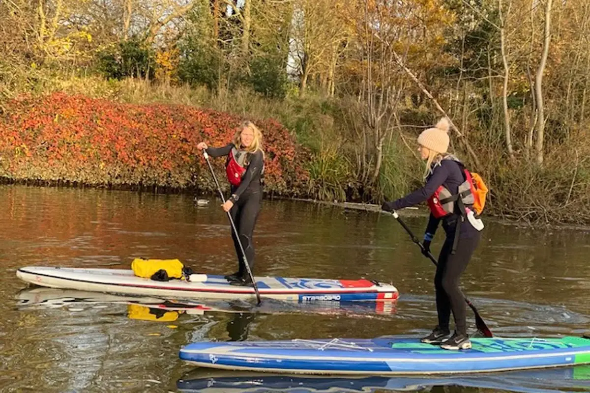 two women paddleboarding on the river in london