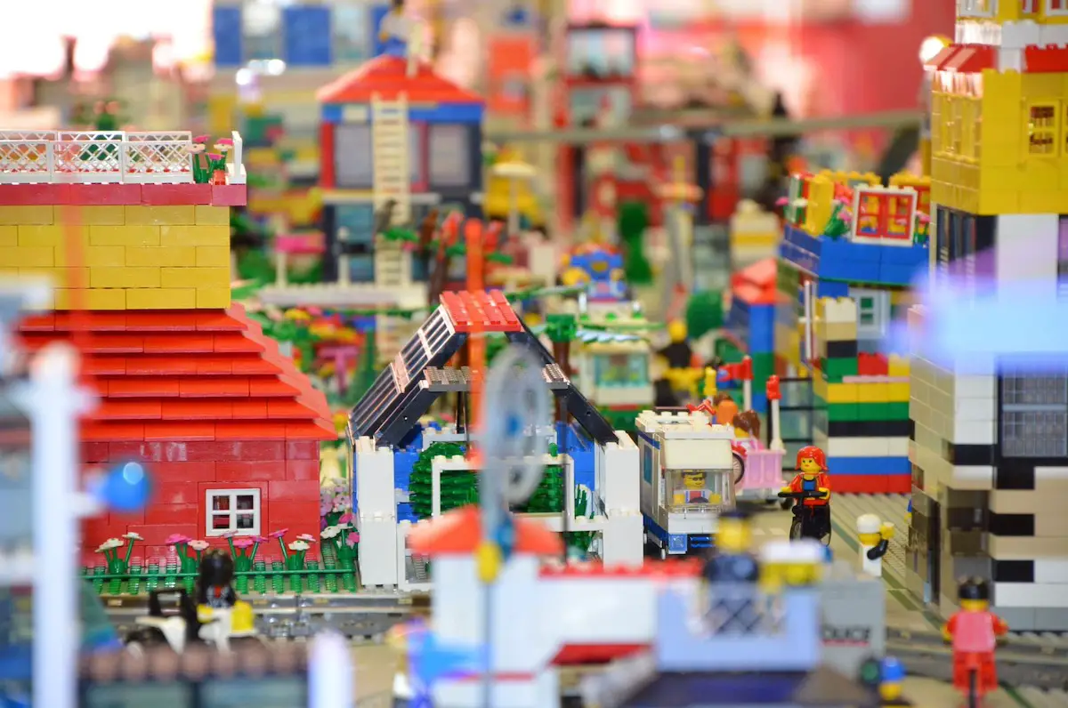 closeup of lego bricks built to resemble a street with a road, buildings and people walking