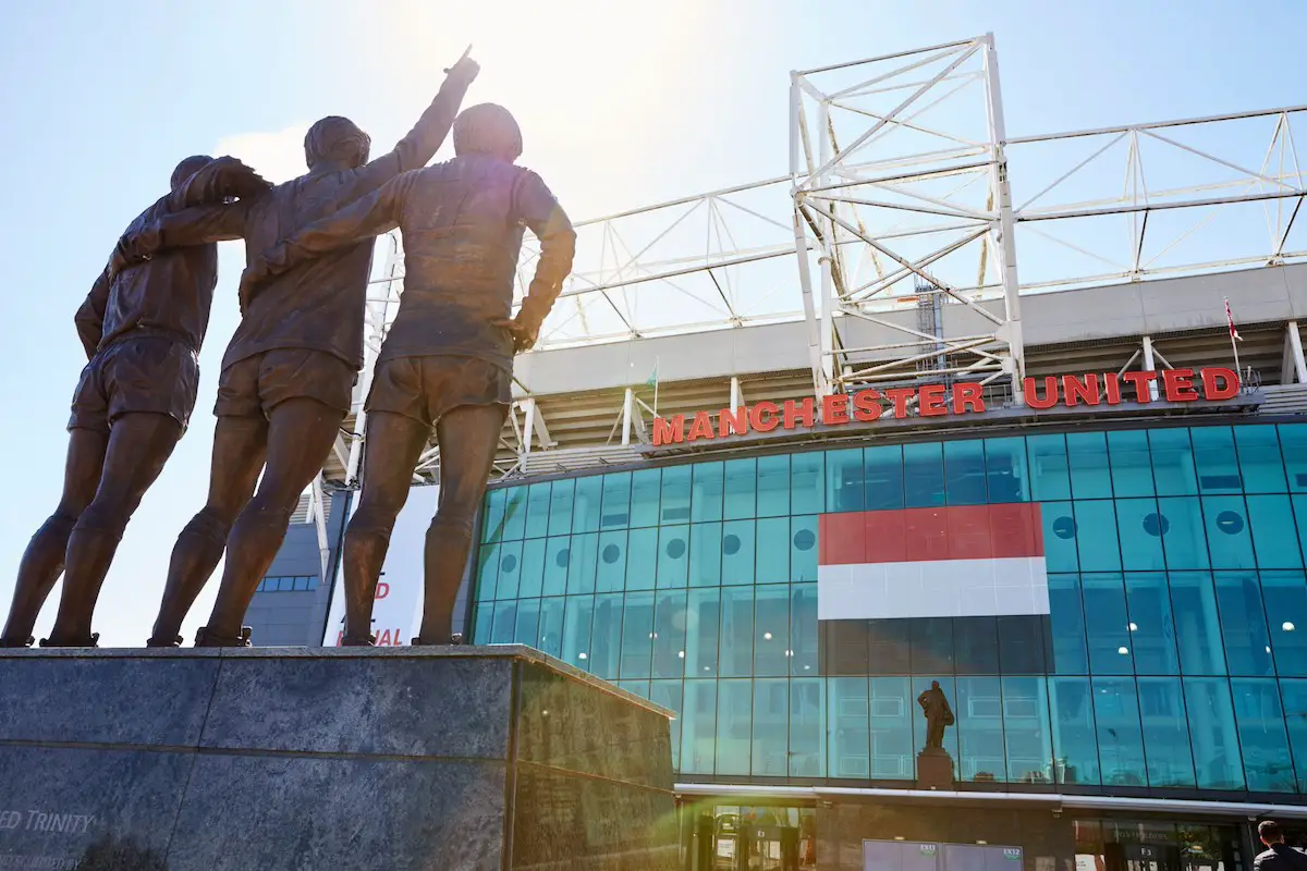 view of the statue of three footballers facing towards the front entrance of manchester united's football stadium